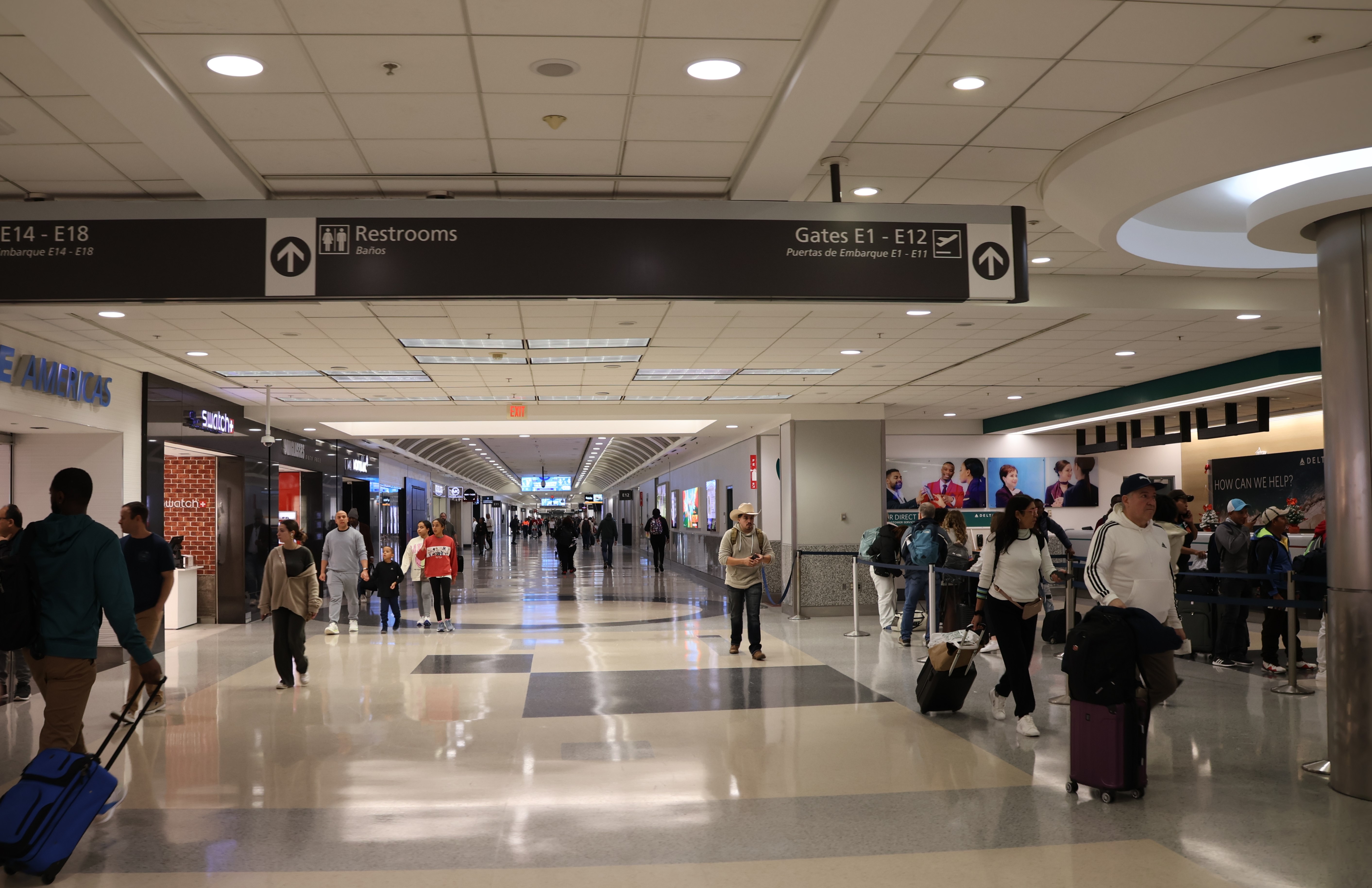 Interior photograph of Concourse E in December 2023, with overhead wayfinding signage pointing to gates E1 to E12