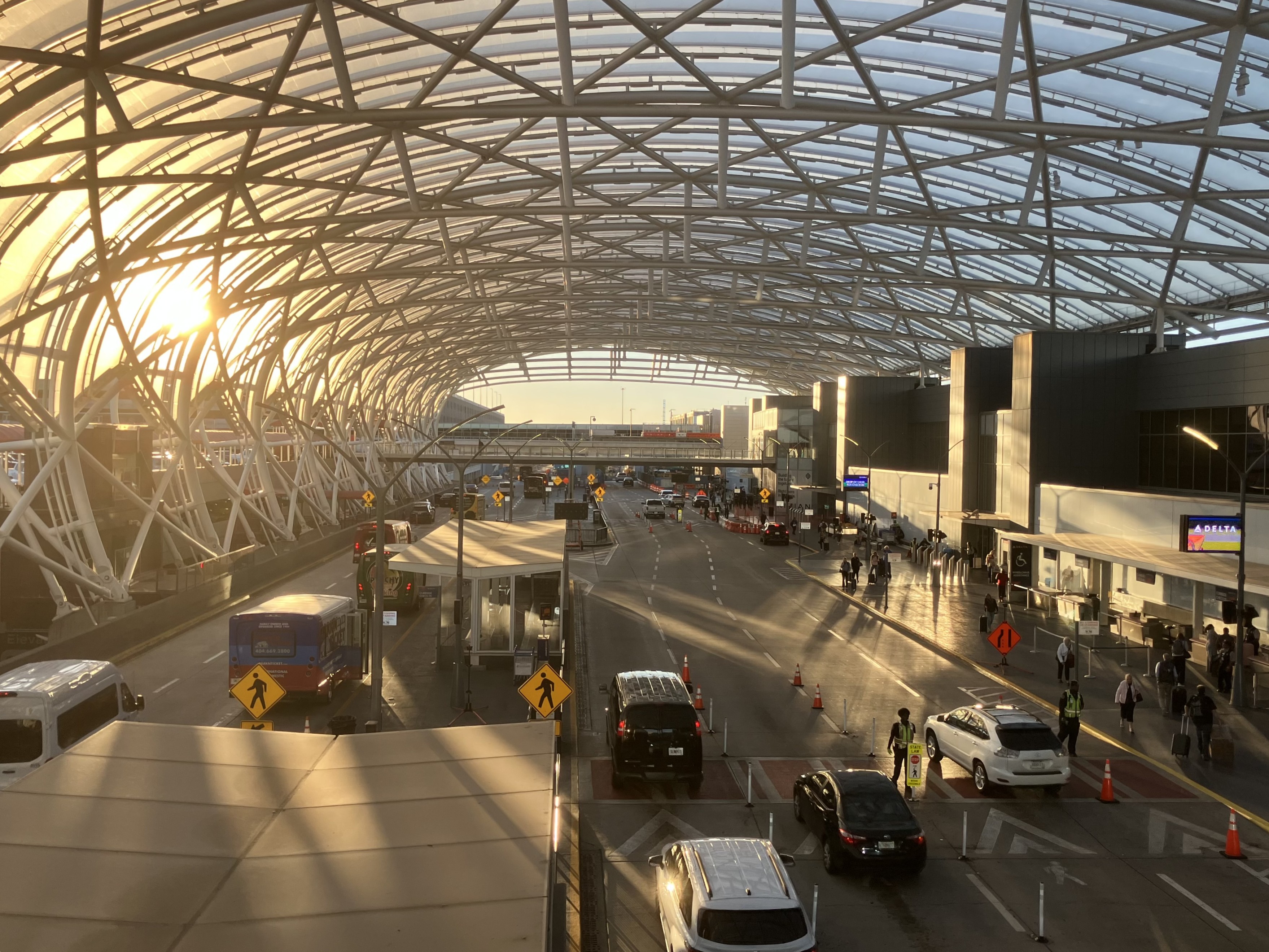 Photograph of the Domestic Terminal South upper-level departures curb in October 2025, with the terminal frontage, canopy and drop-off lanes