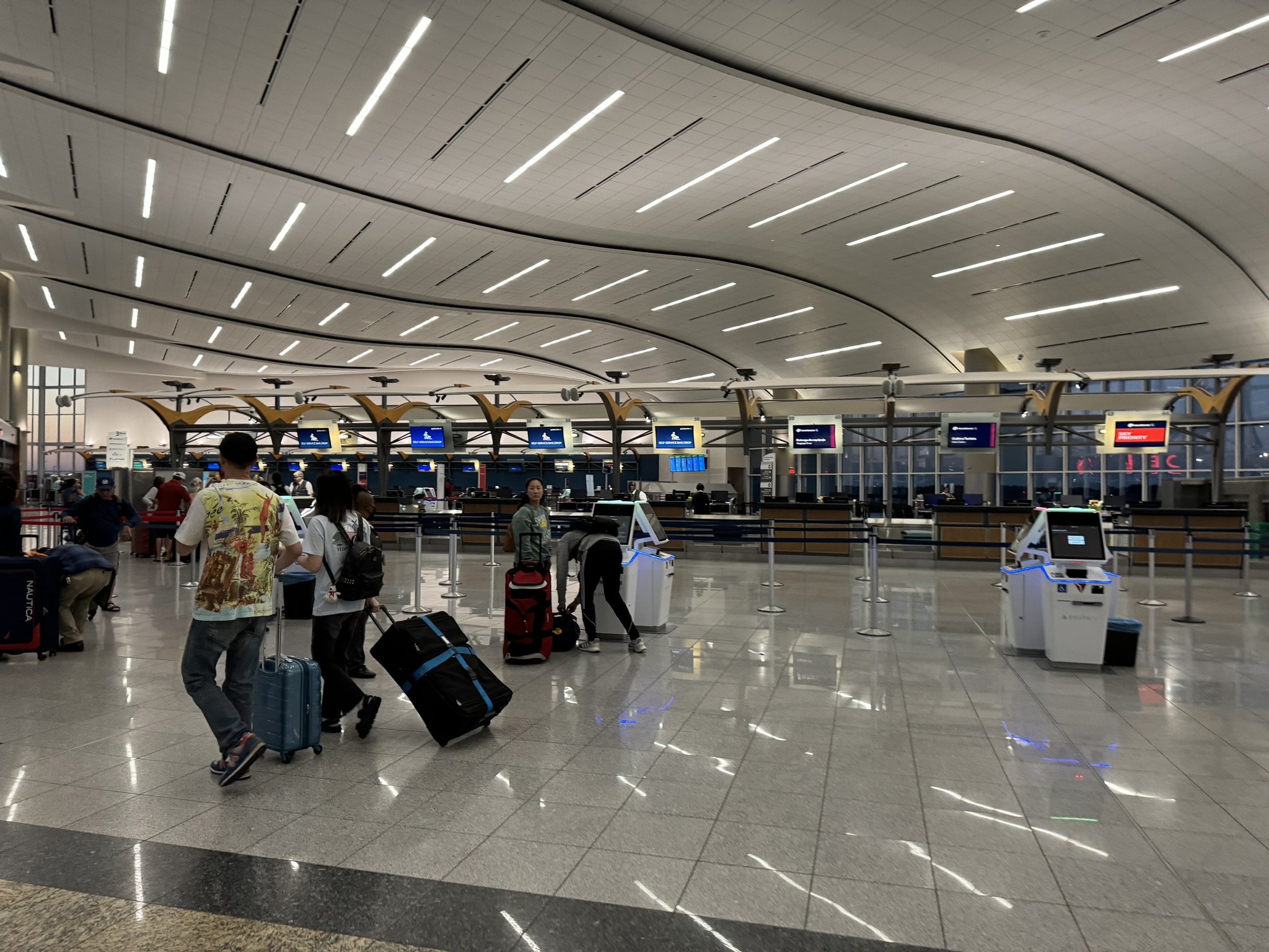 Interior of the Maynard H. Jackson Jr. International Terminal check-in hall, a wide hall with rows of check-in counters, overhead airline signage and a high ceiling